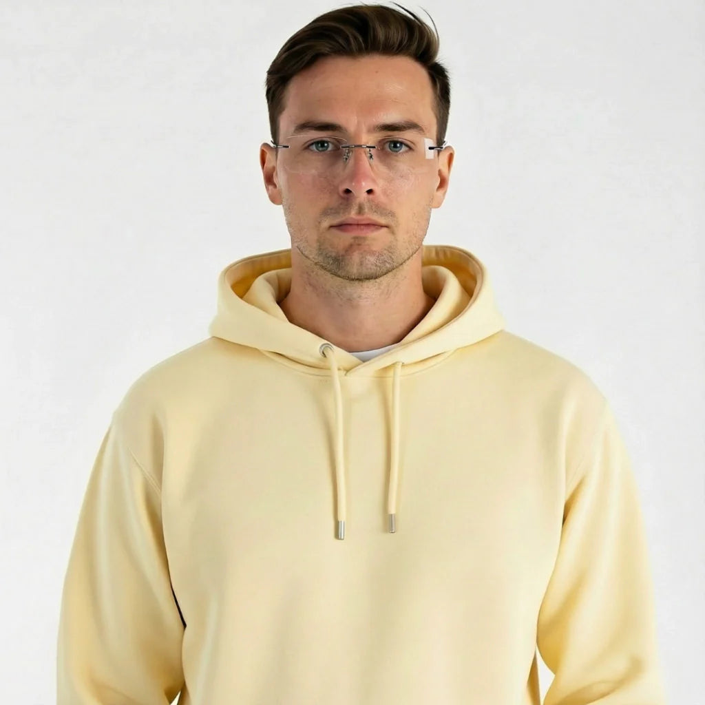Homem usando óculos de grau com armação fina e moletom amarelo claro